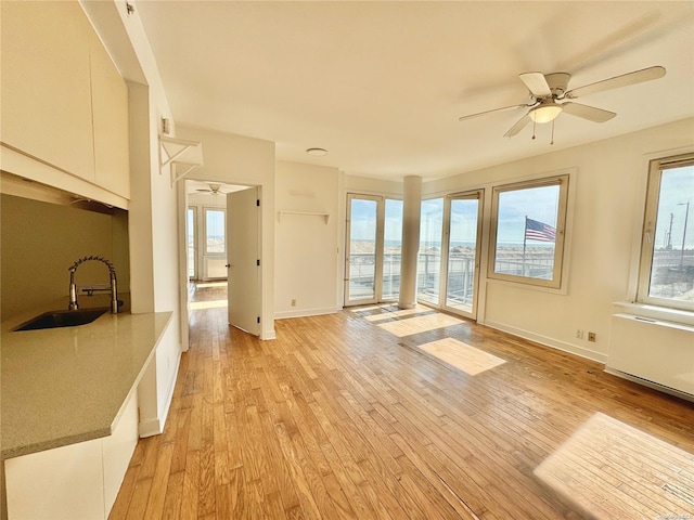 interior space featuring ceiling fan, sink, and light hardwood / wood-style floors