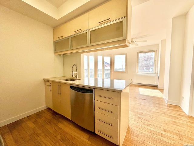 kitchen with dishwasher, light hardwood / wood-style floors, kitchen peninsula, and sink