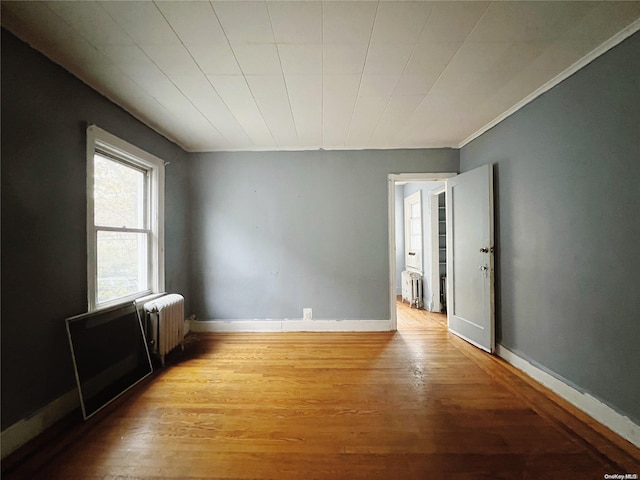 spare room with radiator and light hardwood / wood-style floors