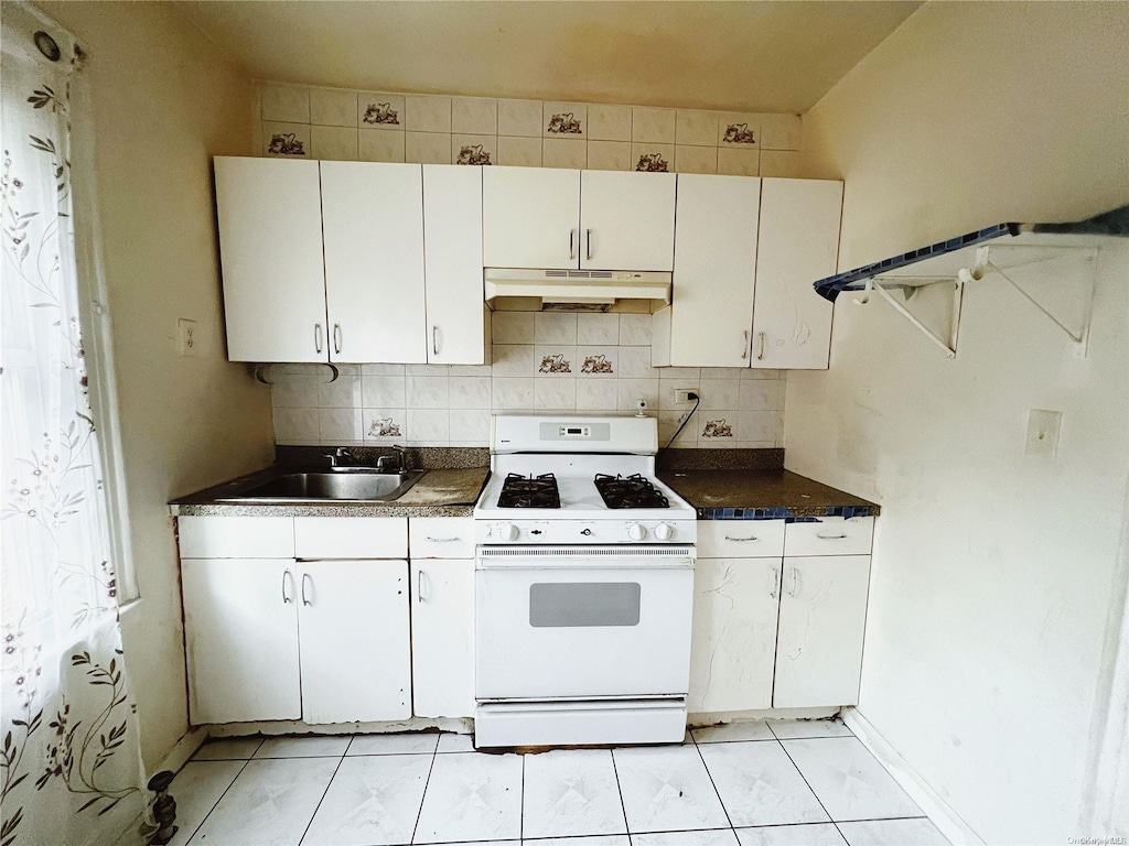 kitchen with tasteful backsplash, white cabinetry, sink, and white range with gas stovetop