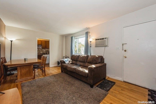 living room featuring wood-type flooring and an AC wall unit