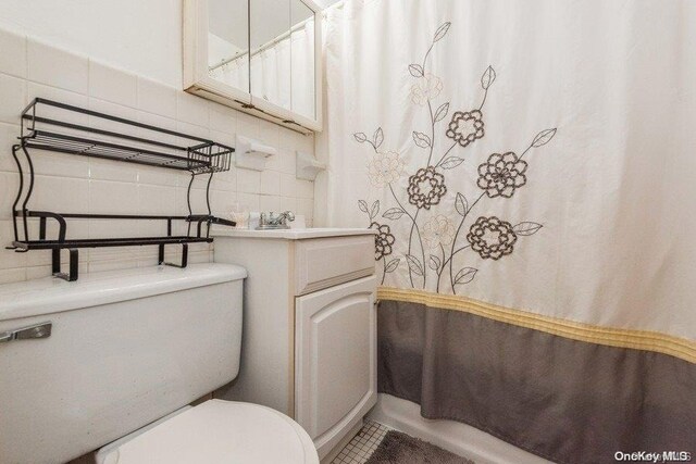 bathroom with backsplash, tile walls, and toilet