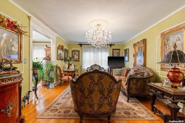 living room featuring light hardwood / wood-style floors, crown molding, and a chandelier