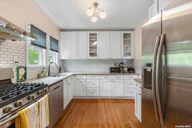 kitchen featuring light wood-type flooring, stainless steel appliances, white cabinetry, and sink