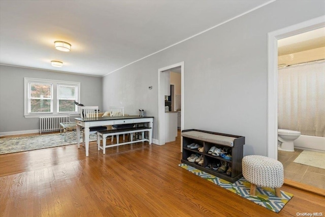 dining space with hardwood / wood-style floors and radiator