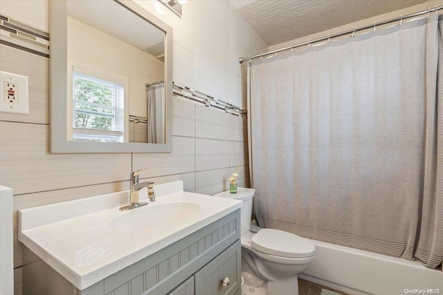 bathroom featuring decorative backsplash, vanity, toilet, and tile walls