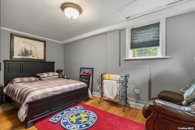 bedroom with light wood-type flooring and ornamental molding