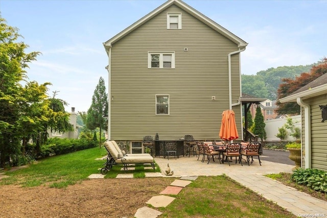 rear view of house featuring a yard and a patio