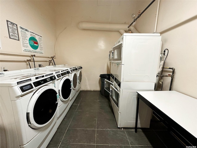 laundry area featuring separate washer and dryer, stacked washer and dryer, and dark tile patterned flooring