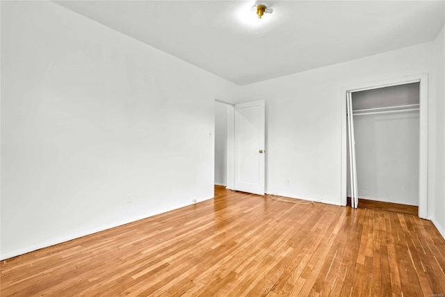 unfurnished bedroom featuring light hardwood / wood-style floors and a closet