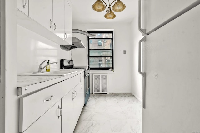 kitchen with white refrigerator, sink, stainless steel range with gas stovetop, and white cabinets