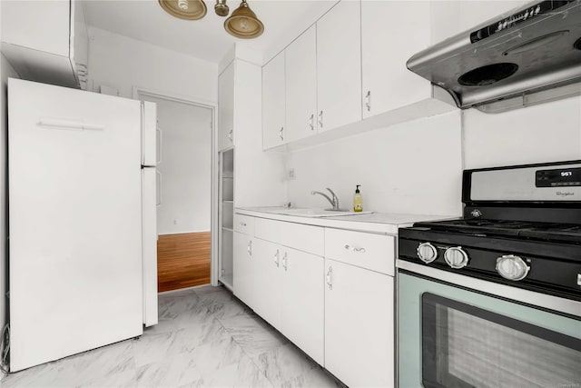 kitchen with white refrigerator, white cabinetry, ventilation hood, and stainless steel gas range