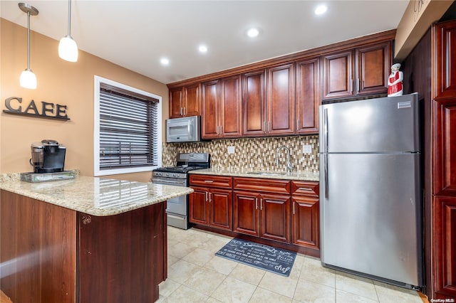 kitchen featuring pendant lighting, sink, appliances with stainless steel finishes, tasteful backsplash, and light stone counters