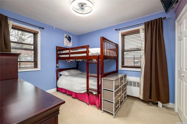 bedroom featuring radiator and light colored carpet