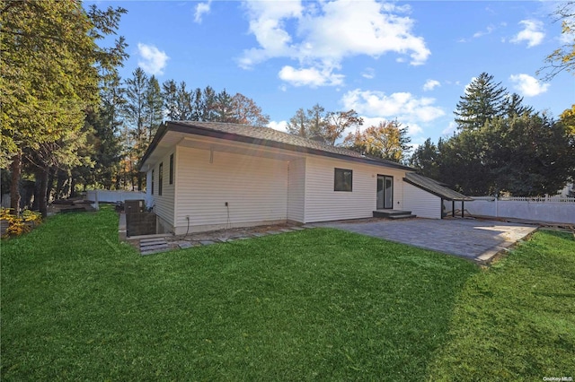 rear view of house featuring a yard and a patio