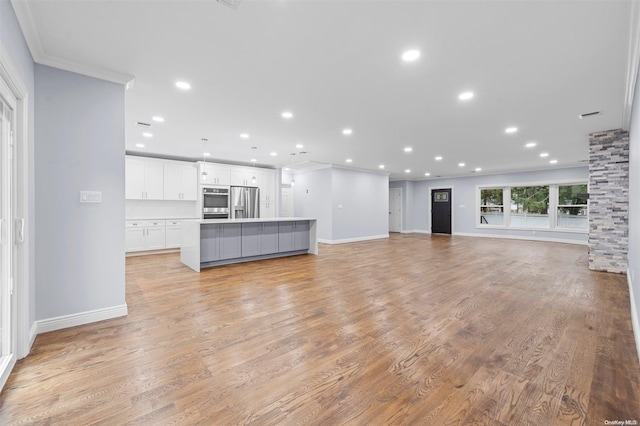 unfurnished living room featuring light hardwood / wood-style flooring and crown molding