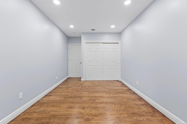 unfurnished bedroom featuring hardwood / wood-style floors and a closet