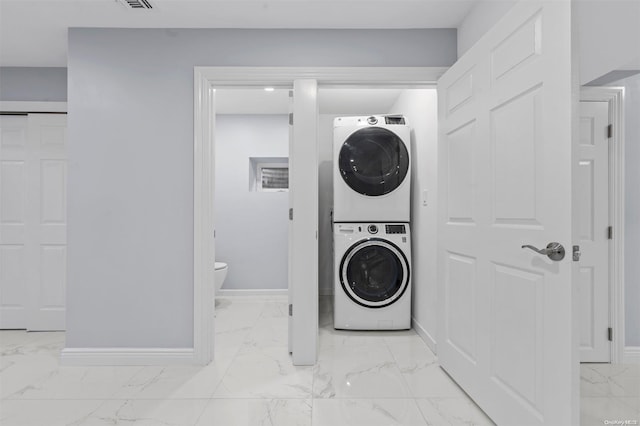 laundry area featuring stacked washer / drying machine