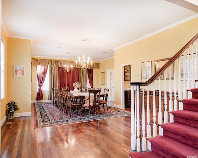 dining room with hardwood / wood-style flooring, ornamental molding, and a chandelier