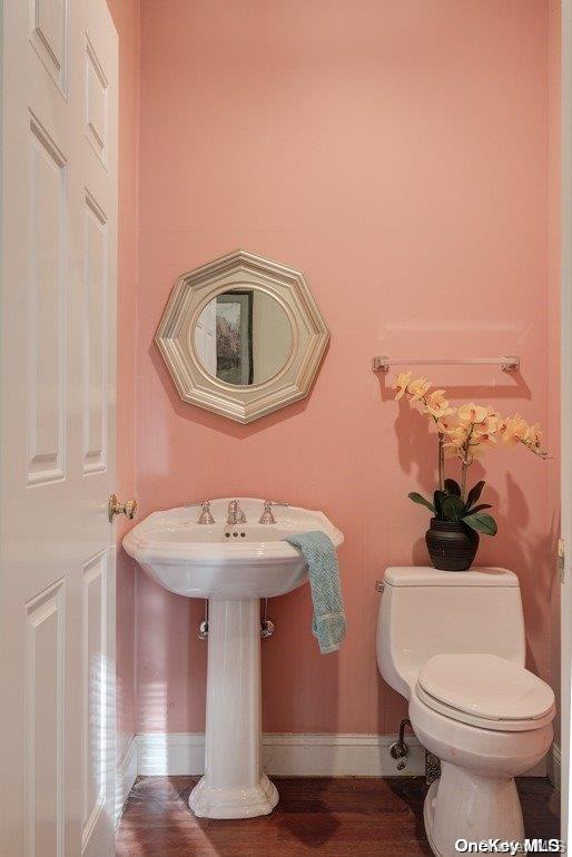 bathroom with toilet and hardwood / wood-style floors