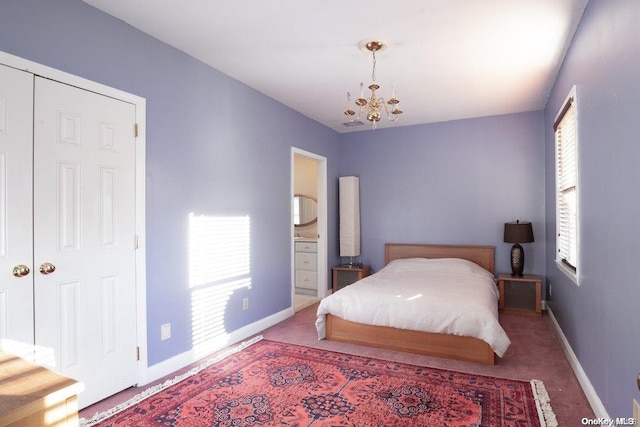 bedroom with an inviting chandelier, ensuite bathroom, and carpet