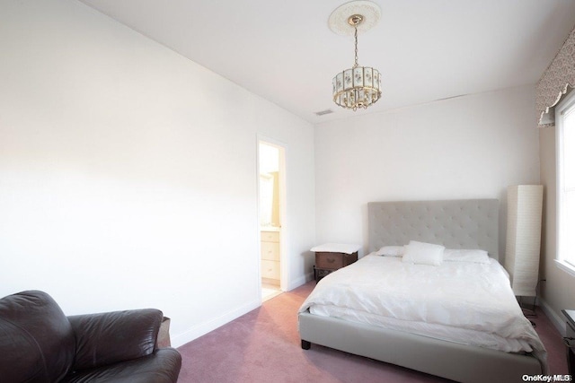 bedroom featuring an inviting chandelier, connected bathroom, and carpet