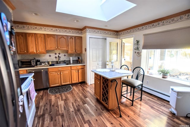 kitchen with a baseboard radiator, dark hardwood / wood-style flooring, appliances with stainless steel finishes, and a skylight