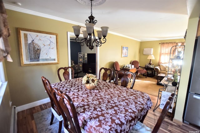 dining room featuring hardwood / wood-style floors, an inviting chandelier, and crown molding