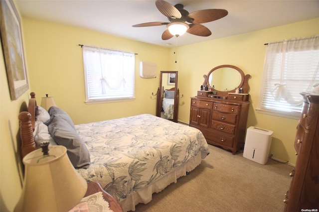 carpeted bedroom with ceiling fan and multiple windows