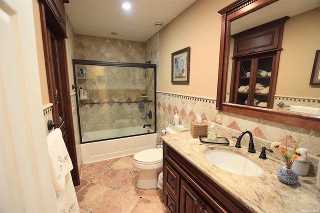 full bathroom featuring vanity, tile patterned flooring, toilet, enclosed tub / shower combo, and tile walls