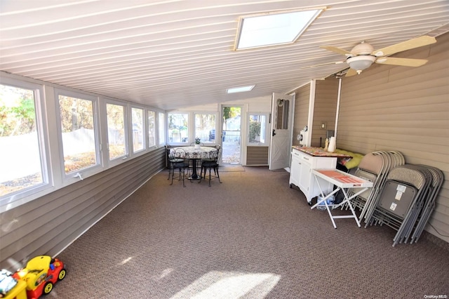 sunroom with ceiling fan and vaulted ceiling with skylight