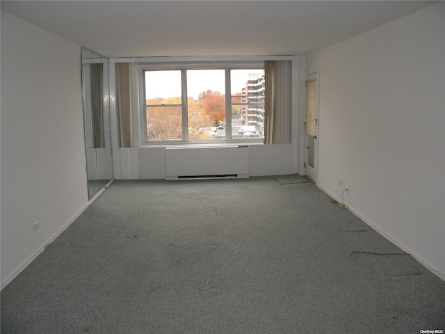 unfurnished room with light colored carpet and radiator