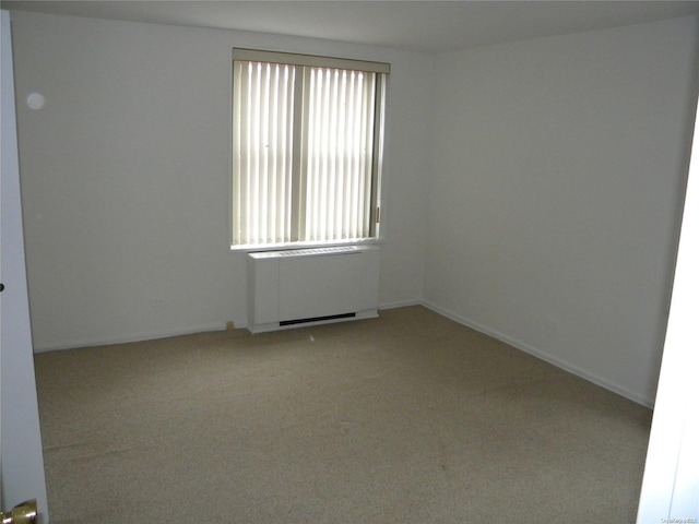 carpeted spare room with radiator heating unit