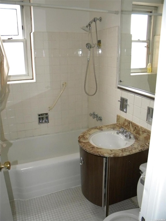 full bathroom featuring tasteful backsplash, tile patterned floors, vanity, tiled shower / bath combo, and tile walls