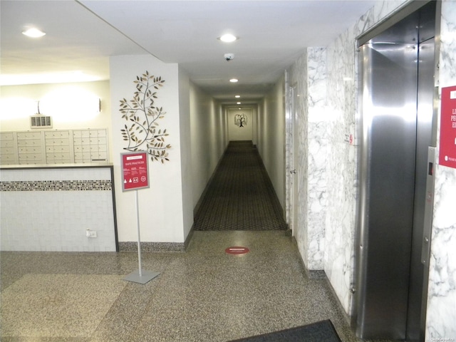 hallway featuring elevator and a mail area