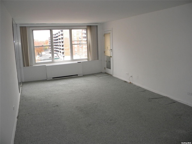 unfurnished room with light carpet and radiator