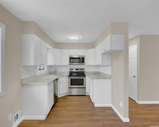 kitchen featuring light hardwood / wood-style floors, white cabinetry, sink, and appliances with stainless steel finishes