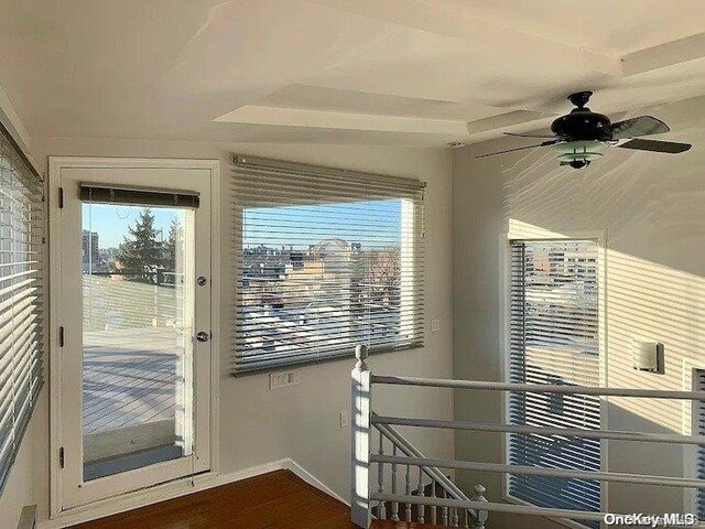 doorway to outside featuring ceiling fan and dark wood-type flooring