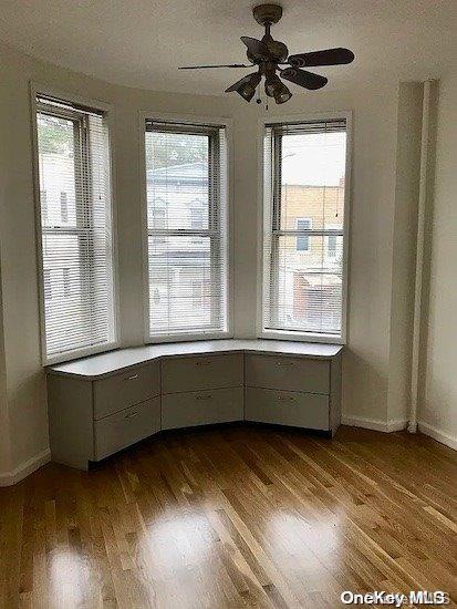 25-54 37th St, Astoria, NY 11103 - unfurnished dining area featuring dark wood finished floors, healthy amount of natural light, and a ceiling fan