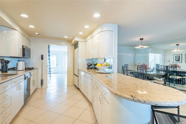 kitchen featuring light stone countertops, white cabinetry, hanging light fixtures, black dishwasher, and light tile patterned flooring