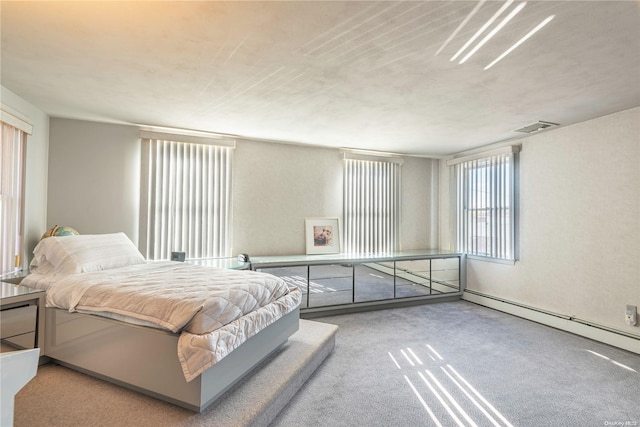 bedroom with light carpet and a baseboard heating unit