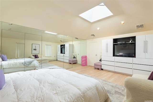 bedroom with hardwood / wood-style floors, a baseboard heating unit, and a skylight