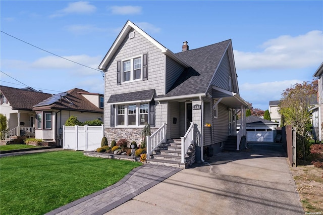 view of front of house with a garage, a front lawn, and an outdoor structure