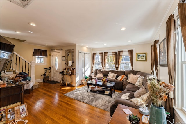 living room with a healthy amount of sunlight, dark hardwood / wood-style floors, and ornamental molding