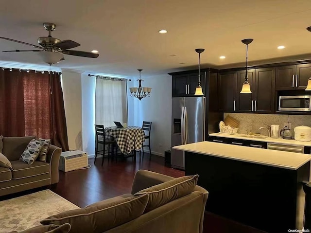 kitchen with appliances with stainless steel finishes, a kitchen island, and hanging light fixtures