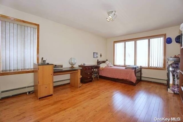 bedroom with baseboard heating and hardwood / wood-style flooring