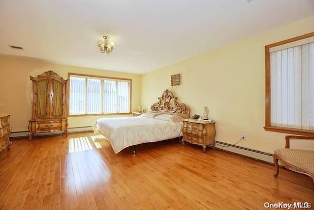 bedroom featuring light hardwood / wood-style flooring and a baseboard heating unit