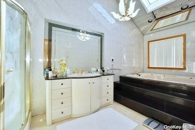 bathroom with tile patterned floors, a skylight, vanity, and shower with separate bathtub