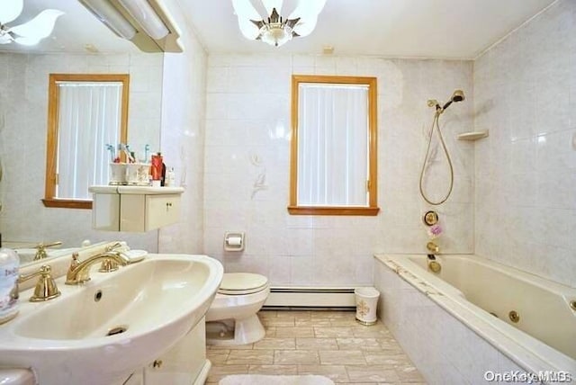 full bathroom featuring sink, tiled shower / bath combo, toilet, baseboard heating, and tile walls