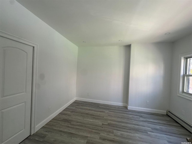 spare room with hardwood / wood-style floors and baseboard heating